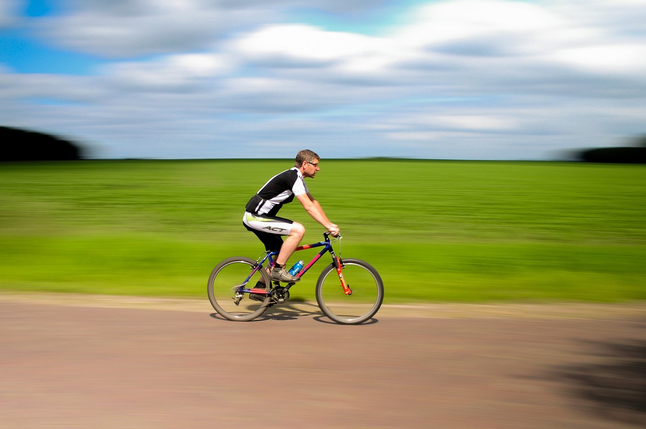 Person cyclying against a backdrop of grass