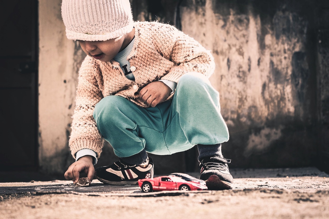 Child playing with a toy car