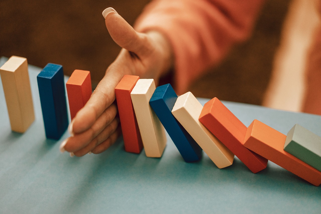 Hand stopping domino blocks from falling