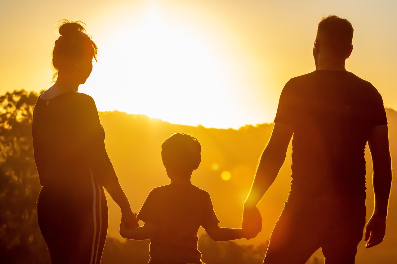 Parents and child against sunset