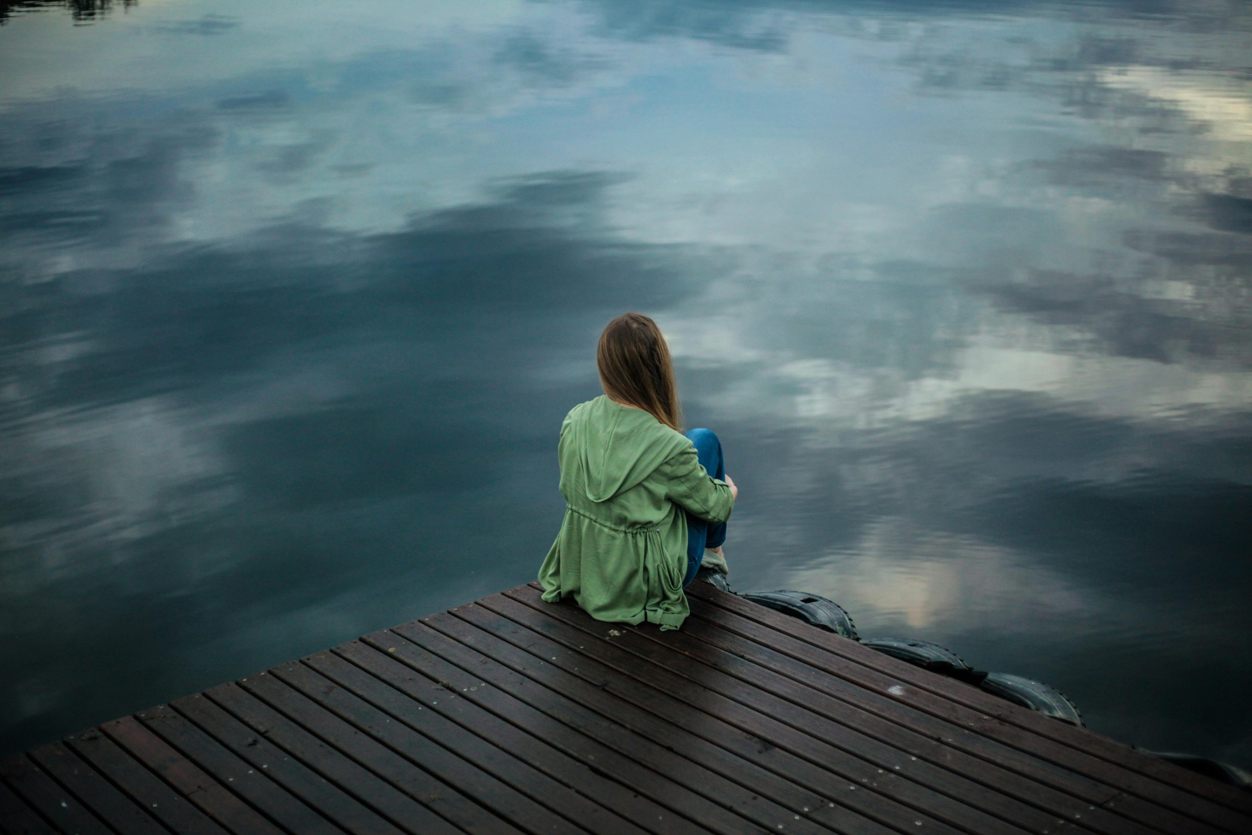 A person sat by a river.