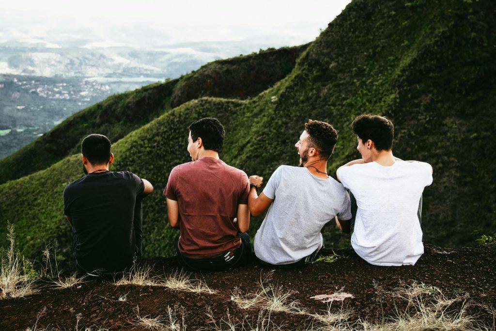 Group of people sat on the top of a mountain.