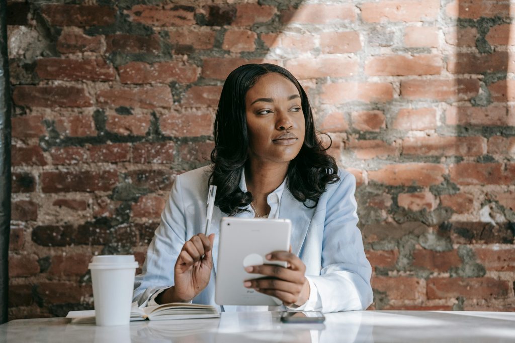 A woman holding an ipad and a pen.