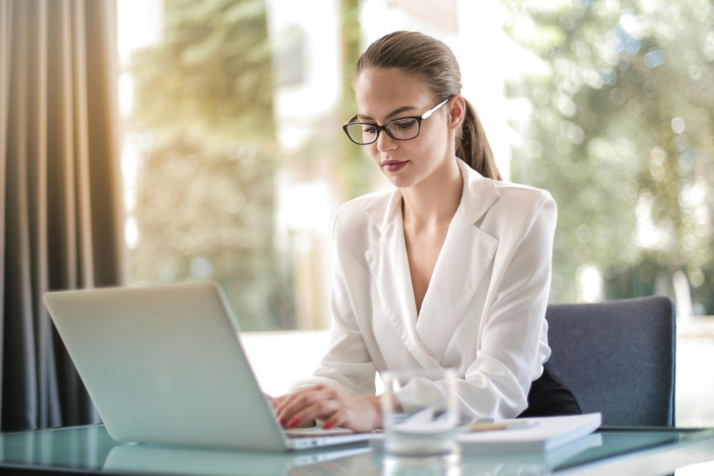 A woman sat at a table with a laptop.