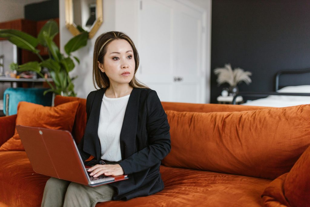 An image of a person looking away from a laptop.