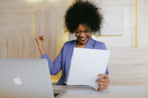 Woman sat behind a laptop and smilling.