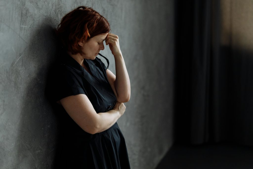 A woman leaning against a wall.