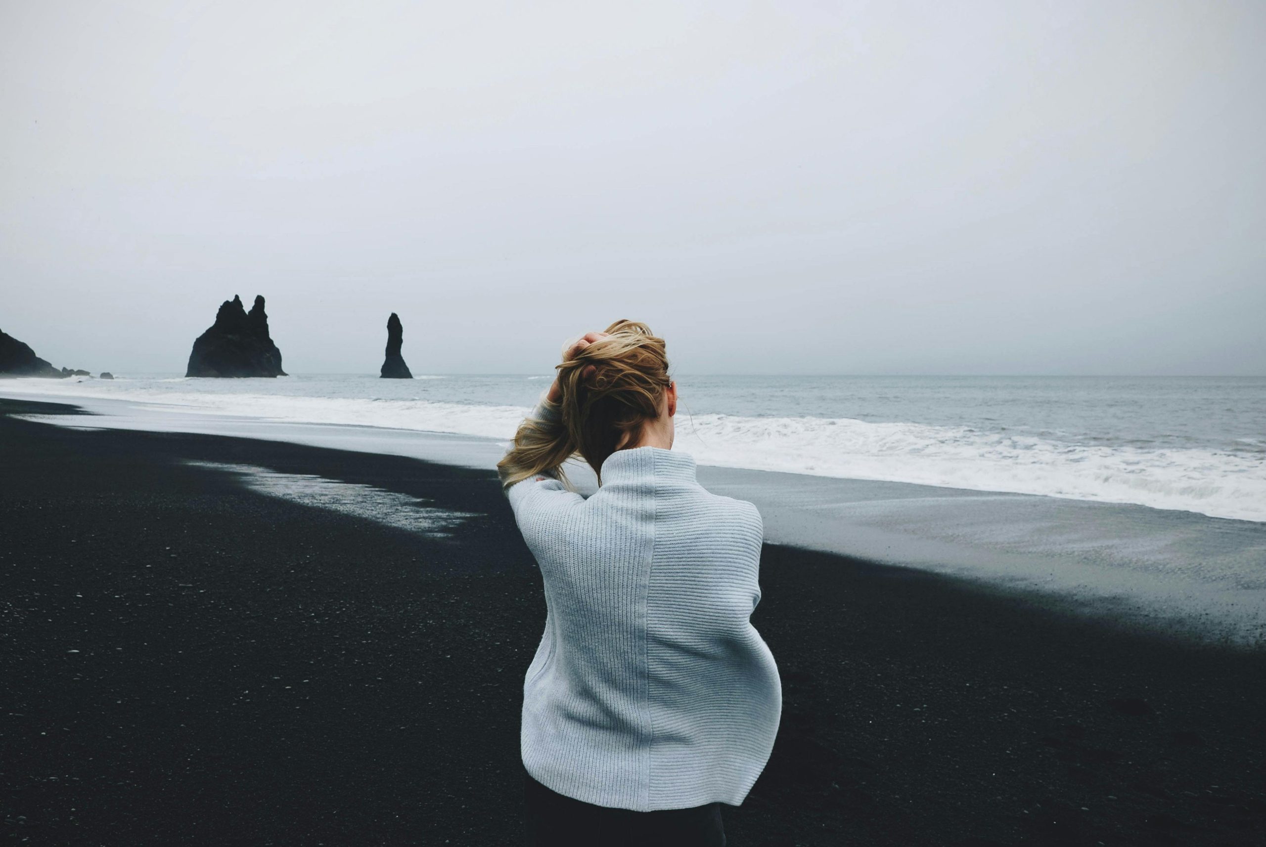 A person sat near the sea.